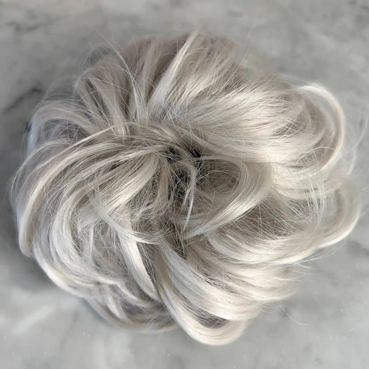 white platinum Blonde hair bun on a light gray background